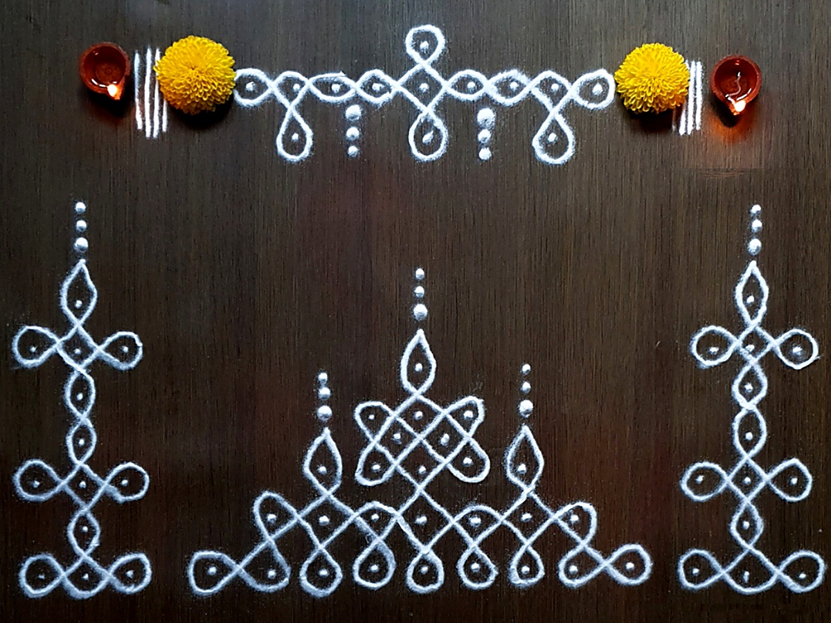 Vasal Padi Threshold Kolam with glowing clay diyas and yellow chrysanthemums by Vinns